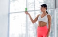 A brunette girl in a white top and coral leggings holds a massage ball in her hands