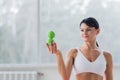 A brunette girl in a white top holds a massage ball in her hands