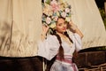 Brunette girl in a white ukrainian authentic national costume and a wreath of flowers is posing against a terrace. Close Royalty Free Stock Photo