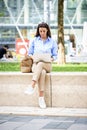 Brunette haired woman sitting on a bench in the city and using a laptop for work Royalty Free Stock Photo