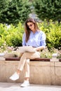 Brunette haired woman sitting on a bench in the city and using a laptop for work Royalty Free Stock Photo