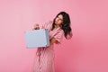 Brunette holds super heavy bag and emotionally poses. Girl with wavy hair posing in motion Royalty Free Stock Photo