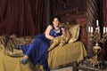 Lady in blue dress on the bed in vintage interior