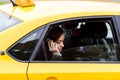 Brunette lady in classic yellow cab talking on mobile phone Royalty Free Stock Photo