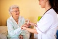 Brunette lady doctor and her nursing home elder woman patient having polite conversation Royalty Free Stock Photo