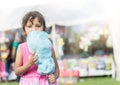 Brunette little girl at the town fair eating cotton candy