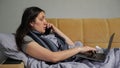 Woman on sick leave works online discussing work via phone Royalty Free Stock Photo