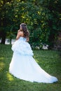 Brunette in a lush blue dress with her hair is set in garden Royalty Free Stock Photo