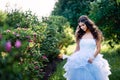 Brunette in a lush blue dress with her hair is set in garden Royalty Free Stock Photo