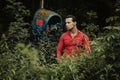 A brunette man of model appearance in a red shirt next to an abandoned telephone booth Royalty Free Stock Photo