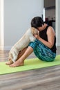 Brunette middle aged woman doing yoga meditation on exercise mat with dog at home, mental health, mental balance, time