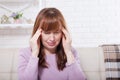 Brunette middle aged woman having headache on home background. Menopause and stress. Depression. Copy space and mock up Royalty Free Stock Photo