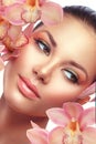 Brunette model girl portrait with orchid flowers
