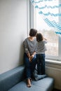 Brunette mother and daughter child spending time at home looking out the window Royalty Free Stock Photo