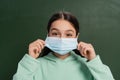 Brunette schoolkid wearing medical mask near