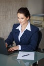 Brunette secretary typing letter on laptop Royalty Free Stock Photo