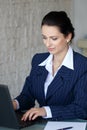 Brunette secretary typing letter on laptop Royalty Free Stock Photo