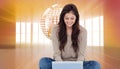 Brunette sitting on floor using laptop