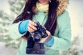 Brunette smiling girl photographed on an old vintage camera in winter forest Royalty Free Stock Photo