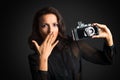 Brunette surprised woman holding vintage camera