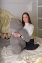Brunette teen girl with big gray bear