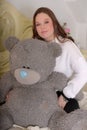 Brunette teen girl with big gray bear