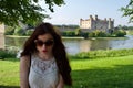 Brunette teenage girl with sunglasses, posing by stone castle