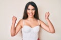 Brunette teenager girl posing elegant celebrating surprised and amazed for success with arms raised and open eyes Royalty Free Stock Photo