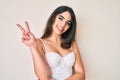 Brunette teenager girl posing elegant showing and pointing up with fingers number two while smiling confident and happy Royalty Free Stock Photo