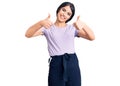 Brunette teenager girl wearing casual clothes approving doing positive gesture with hand, thumbs up smiling and happy for success Royalty Free Stock Photo
