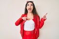 Brunette teenager girl wearing red leather jacket angry and mad screaming frustrated and furious, shouting with anger looking up