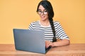 Brunette teenager girl working using computer laptop looking positive and happy standing and smiling with a confident smile Royalty Free Stock Photo