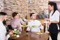 Brunette waitress and unhappy people in a cafe Royalty Free Stock Photo