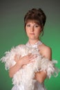 brunette in white dress with feather boa on green Royalty Free Stock Photo