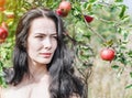 Brunette in a wild apple orchard. Portrait on the backgroun