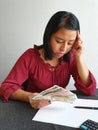 brunette woman analyzing economic budget and holding cuban money