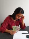 brunette woman analyzing economic budget and holding Singaporean money