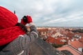 Brunette Woman With Big Cozy Red Scarf, Hat and Mittens Making Photos of Prague Sights. View on Prazhsky Hrad, Old Town
