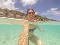 Brunette woman in bikini and sunglasses swimming taking a selfie Royalty Free Stock Photo
