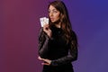 Brunette woman in black velvet dress showing two playing cards, posing against coloful background. Gambling Royalty Free Stock Photo