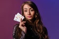 Brunette woman in black velvet dress showing two playing cards, posing against coloful background. Gambling Royalty Free Stock Photo