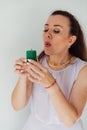 brunette woman blowing out a burning green candle