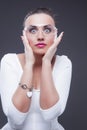 Brunette Woman With Both Hands Lifted Near Face. Against Gray Background