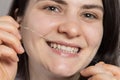 A brunette woman brushes her teeth with flossing. Oral hygiene, plaque removal and prevention of tooth decay and gum Royalty Free Stock Photo