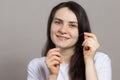 A brunette woman brushes her teeth with flossing. Oral hygiene, plaque removal and prevention of tooth decay and gum Royalty Free Stock Photo