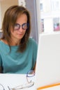 Brunette woman choosing and buying eyeglasses in optician salon or shop Royalty Free Stock Photo