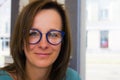 Brunette woman choosing and buying eyeglasses in optician salon or shop