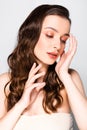 Brunette woman with curls and makeup gesturing  on grey Royalty Free Stock Photo