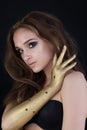 Brunette woman with curly brown hair, smoky eyes makeup and golden hand, fashion portrait Royalty Free Stock Photo