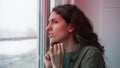 Woman looks out of window at crime scene with police lights